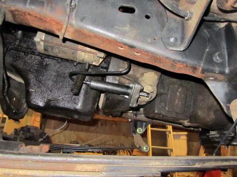 1984 Ford Bronco - Close-up of vehicle undercarriage, focusing on mechanical components like the transmission and fuel tank.