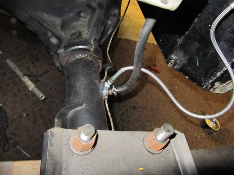 1984 Ford Bronco - Close-up view of a vehicle's rear axle assembly, showing brake lines and mounting hardware.