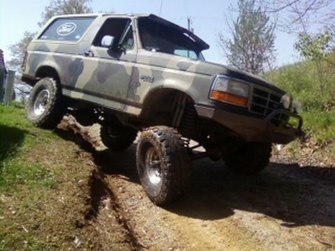 1995 Ford Bronco - This Ford Bronco is shown off-roading on a steep, muddy incline.