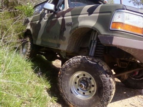 1995 Ford Bronco - This Ford Bronco is covered in camouflage and appears to be off-roading.