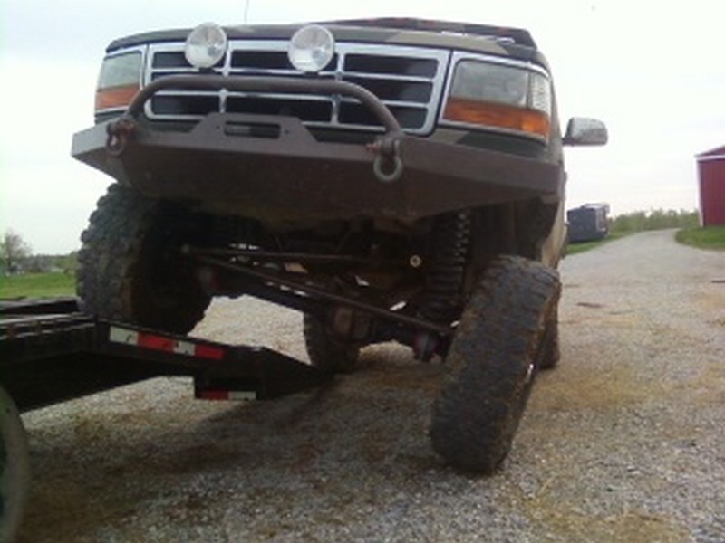 Dark SUV with aftermarket bumper and large tires, front 3/4 view. 1995 Ford Bronco