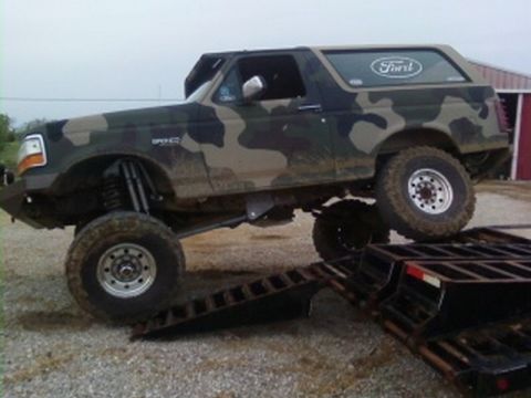 1995 Ford Bronco - This lifted 1995 Ford Bronco is shown in a camouflage paint scheme while being loaded onto a trailer.