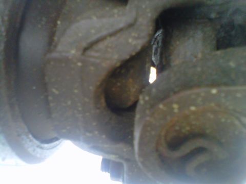 1994 Ford F-150 - This image shows a close-up view of a vehicle's driveshaft U-joint, a critical component for power transmission.