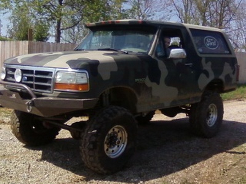 Camouflaged 1995 Ford Bronco, 3/4 front view, lifted with aftermarket bumper