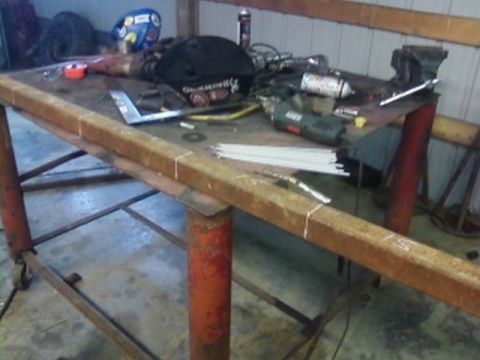 1995 Ford Bronco - Workbench cluttered with tools and metal stock, ready for fabrication.