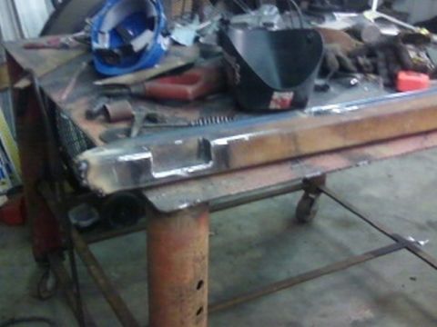 1995 Ford Bronco - Metal rock sliders are shown on a workbench with various tools and safety gear.