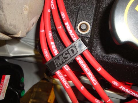 1989 Ford Bronco - Close-up of red MSD ignition wires with Ford Racing branding, secured by a black MSD wire loom clip.