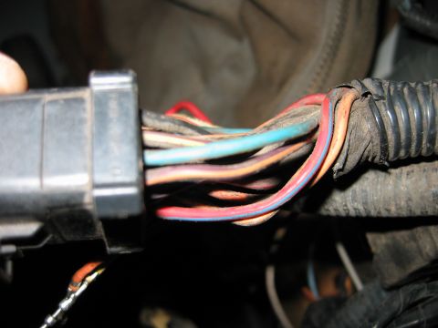 1992 Ford Bronco - A close-up view of a vehicle's wiring harness, showing multiple colored wires bundled together.