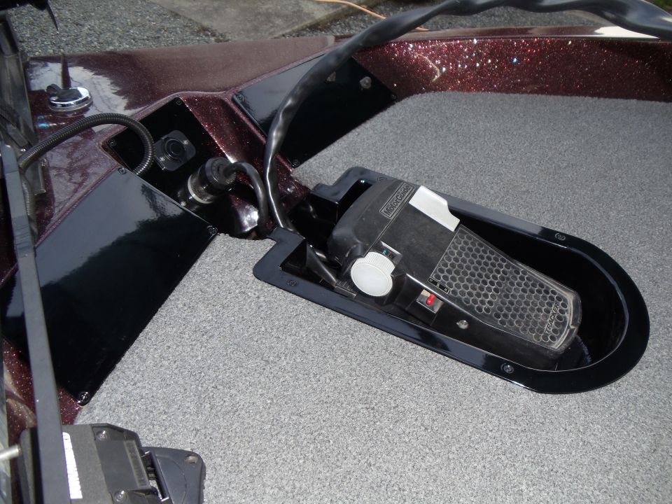 MotorGuide trolling motor foot pedal in the bow deck well of a maroon bass boat