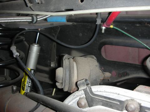 1998 Ford Crown Victoria - Close-up view of rear suspension components, including a shock absorber and a rubber mount.