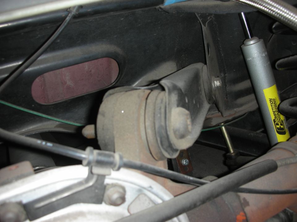 Underbody suspension bushing mount beside coil spring and yellow shock
