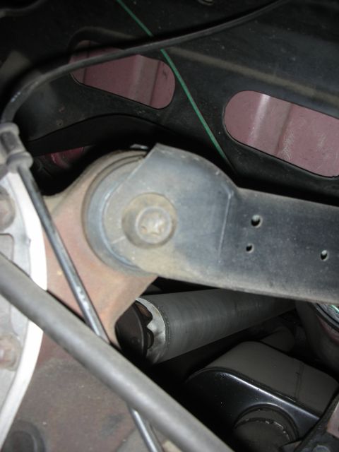 1998 Ford Crown Victoria - This photo shows a close-up view of a vehicle's rear suspension component, including a metal arm and bracket.