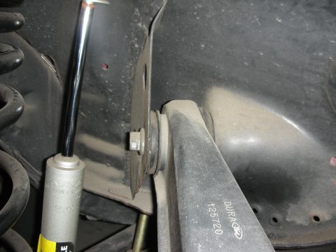 1998 Ford Crown Victoria - Close-up of a vehicle's rear suspension system, showing a shock absorber and control arm.