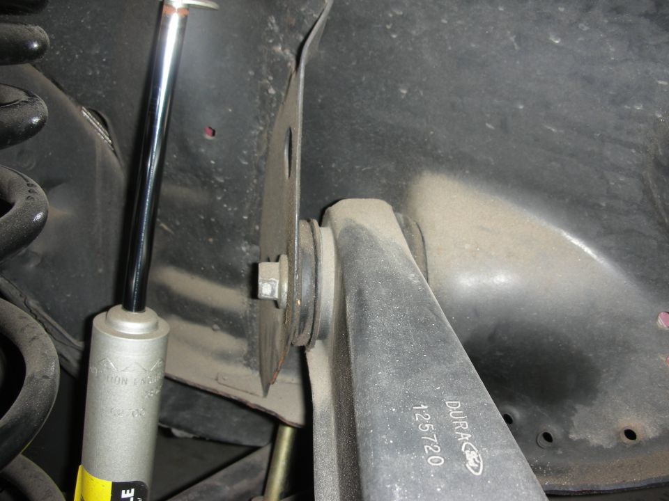 Ford-branded suspension arm marked DURA 125720 beside chrome shock shaft