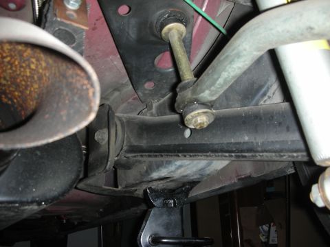 1998 Ford Crown Victoria - Close-up view of the rear suspension system, including the exhaust and sway bar, on a vehicle.