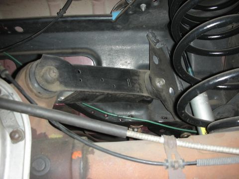 1998 Ford Crown Victoria - Undercarriage view of a vehicle's rear suspension system, showing linkages and springs.
