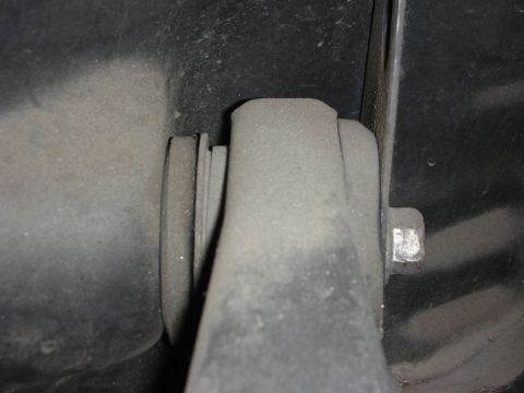 1998 Ford Crown Victoria - A close-up view of a dusty rear suspension component, showing a bolt and mounting bracket.