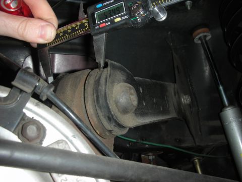 1998 Ford Crown Victoria - Close-up of a suspension component being measured with a digital caliper.