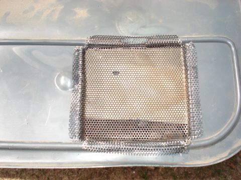 1992 Ford C-350 (Centurion Conversions) - Metal mesh patch applied to a gray plastic panel, likely for repair or ventilation.