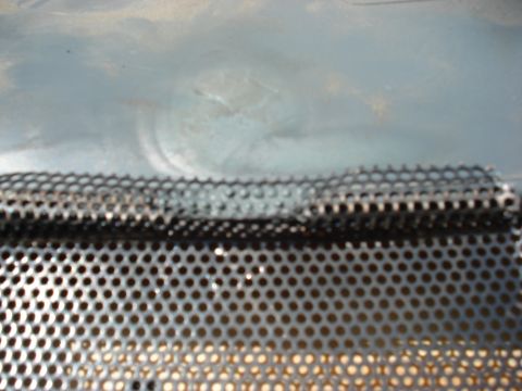 1992 Ford C-350 (Centurion Conversions) - A close-up view of a perforated metal panel, possibly from a vehicle's interior or exterior component, with a Supermotors watermark.