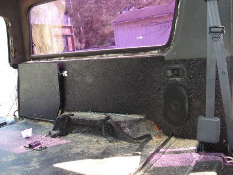 1992 Ford C-350 (Centurion Conversions) - Rear wall of a truck cab finished in black textured carpet/liner, with a 6x9 aftermarket speaker and a small tweeter mounted in the panel a…