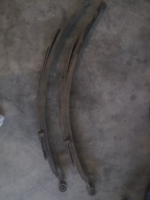 1994 Ford Bronco - Pair of used leaf springs, likely for a truck or SUV, shown on a concrete surface.