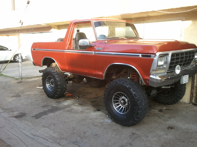 Orange 1978 Ford Bronco with lifted suspension and large tires