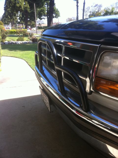 1995 Ford Bronco - Close-up of a Ford truck's front end, showing the grille, headlights, and a protective bull bar.