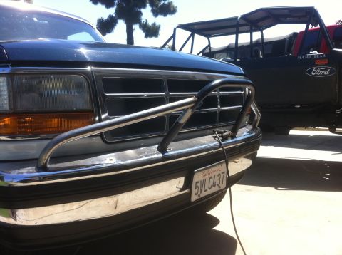 1995 Ford Bronco - A dark-colored Ford truck is seen from the front, equipped with a chrome brush guard and a California license plate.