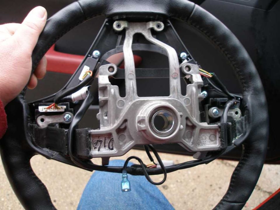 Steering wheel assembly with visible wiring and metal components. Part number '710' visible