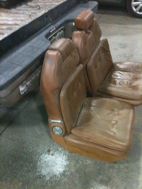 1989 Ford F-250 - A set of brown leather bucket seats are shown, with a portion of a truck bed in the background.