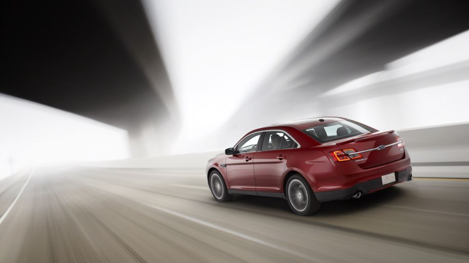 Red sedan driving through a tunnel, rear view