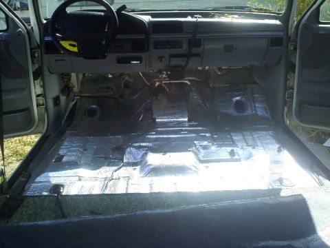 1994 Ford Bronco - The interior of a vehicle is shown with the floor stripped down to the metal and covered in sound deadening material.