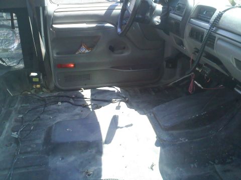 1994 Ford Bronco - Interior view of a 1994 Ford Bronco, showing the floor stripped bare and wiring exposed.