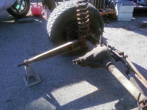 1989 Ford Bronco - Front axle assembly with coil spring and suspension components is shown on jack stands.