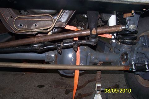 1989 Ford Bronco - Underneath view of a vehicle's front axle and steering system, likely during a repair or modification.