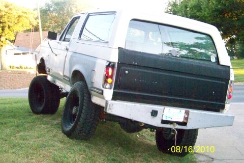 1989 Ford Bronco - This lifted 1989 Ford Bronco features oversized tires and a custom rear bumper, suggesting modifications for off-road use.