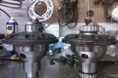 1999 Chevrolet Camaro - Differential gears are displayed on a workbench, alongside various tools and a can of lubricant.