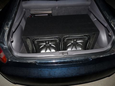 2006 Ford E350 - The trunk of a car is shown with a large subwoofer box containing two subwoofers and an amplifier installed.