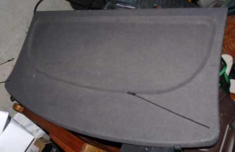 2006 Ford E350 - A gray fabric rear cargo cover is shown, with a thin black cord extending across its surface.