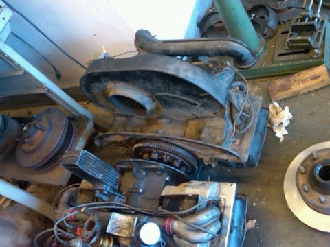 1995 Ford F-150 - Various engine parts and brake rotors are scattered on a workshop floor, with a drill press in the background.