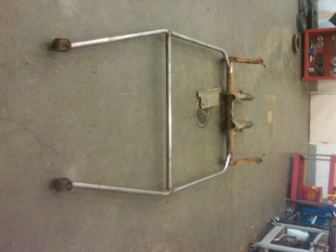 1995 Ford F-150 - A metal frame, possibly part of a custom project or vehicle modification, rests on a concrete floor in a workshop setting.