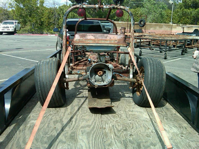 Custom dune buggy project on a trailer, rear view. White SUV in background