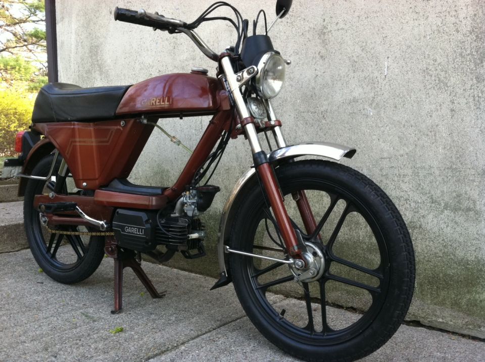 Brown moped with black wheels and chrome fender. Garelli logo visible on engine