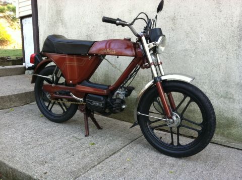 1981 Garelli Rally Sport - This Garelli moped is parked on a concrete surface next to a wall.