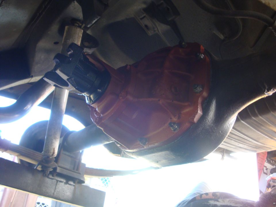 Underside view of rear axle with orange-painted third member and driveshaft attached