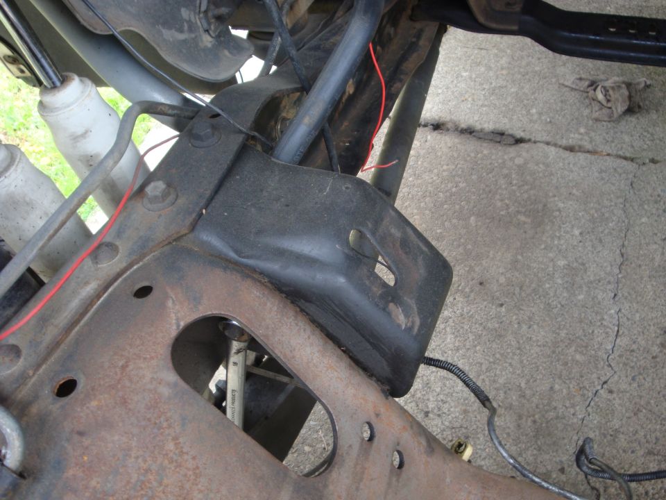 close-up of rusty vehicle frame with suspension parts and wiring