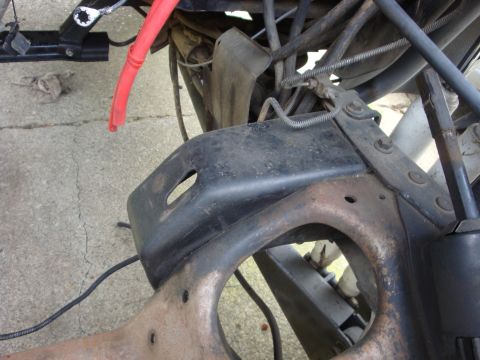 1989 Ford Bronco - Close-up view of vehicle frame and engine components, with a red hose visible.