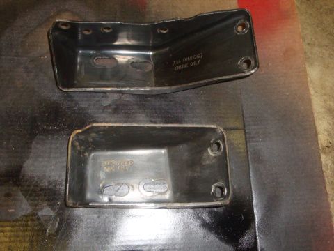 1989 Ford Bronco - Two black metal engine mounts are shown, one stamped with engine size and type.