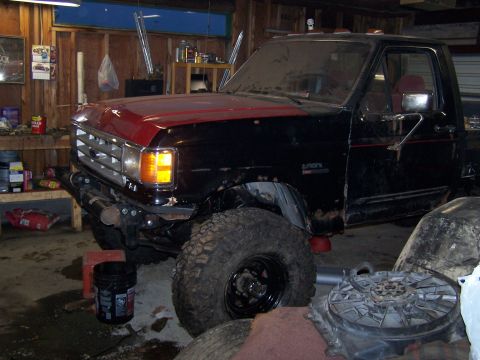 1988 Ford F-250 - This 1988 Ford F-250 pickup truck is shown in a garage with a red hood and black body.
